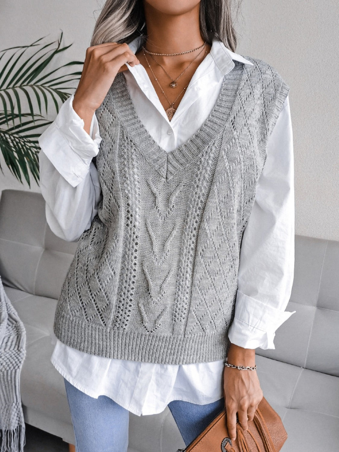 Woman in a knit vest with a white button-down shirt